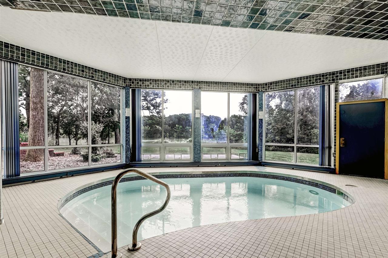 Hot tub with glass windows surrounding it on a waterfront property in the Fox Cities