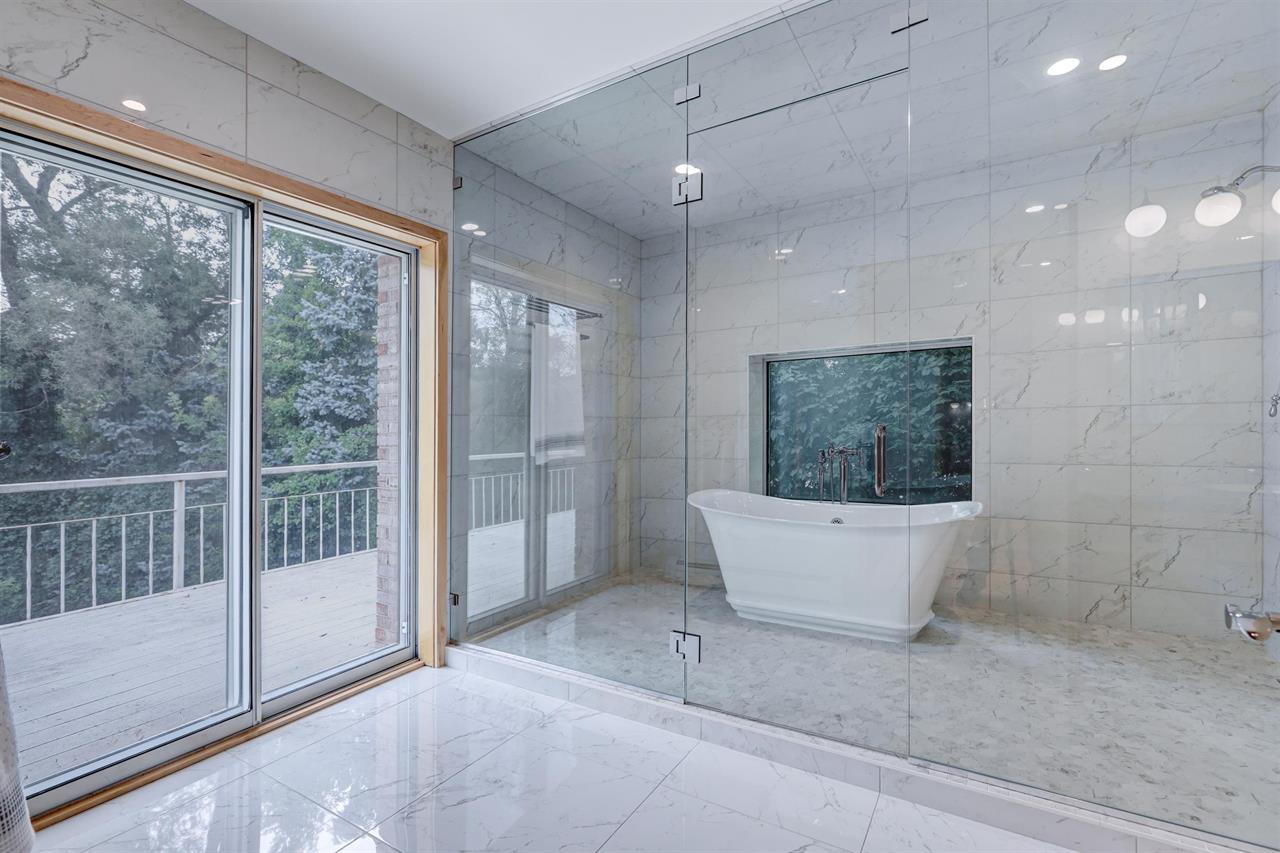 White granite bathroom with a glass enclosed bath tub in the Fox Valley